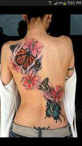 Full Back Butterfly And Lilly Tattoo I Want Something Like This But Smaller Butterfly Tattoos For Women Butterfly Tattoo Designs Tattoos For Women