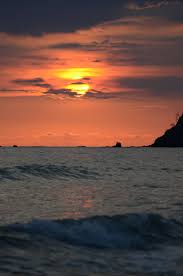 Sea waves at sandy beach at sunset, sun hiding behind a cloud. Sunset Waves Pictures Download Free Images On Unsplash