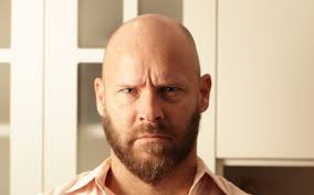 Man with shaved head and beard is going bald