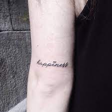 Word Happiness Inked In A Minimalist Font On The Back Of The Left Upper Arm Happiness Tattoo Word Tattoos Tattoos
