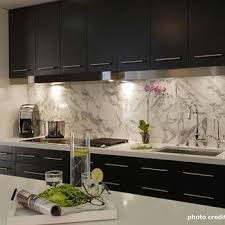 This kitchen with dark kitchen cabinets and a white quartz countertop has a stone mosaic backsplash that fits in perfectly. Modern Espresso Cabinets Design Ideas