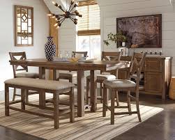 The table rests on a large pedestal loaded with features such as wine bottle storage and storage doors. Moriville Counter Height Dining Table And 4 Barstools And Bench With Storage D631 09 124 4 32 60 Dining Room Groups Cummings Furniture