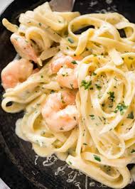 Buttery, garlicky shrimp tossed in a creamy parmesan white wine sauce, then folded into a bed of angel hair pasta and topped with fresh herbs—and it's all ready in just under 30 minutes. Creamy Garlic Prawn Pasta Recipetin Eats