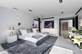 A white fireplace and ceiling beams balance dark walnut floors. Modern Gray And White Bedroom Novocom Top