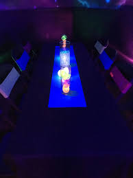 Neon Table Runners With Light Up And Glow Centerpieces Paired With Matching Neon Chair Bands Add A Pop Of Color To The Party Neon Party Chair Bands Bar Mitzvah