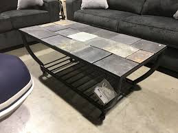 Remote controls, magazines, popcorn bowls… your living room table has a lot to take care of. Stone Tile Top Rolling Coffee Table