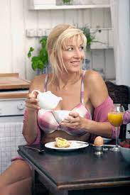 Deutschland, München, Reife Frau beim Frühstück in der Küche, lizenzfreies  Stockfoto