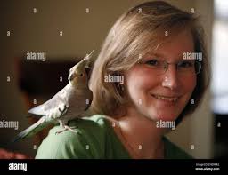 Jennifer Guild poses with her bird, Jellybean, at her home in Richmond,  Va., Monday, April 12, 2010. Jellybean is the nippy childhood bird of  Guild. (AP Photo/Steve Helber Stock Photo