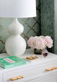 A set of three complementing pieces of wall art with a beautiful gold finish feathers and neutral backing tones. White Nightstand With Gold Bamboo Hardware Transitional Bedroom