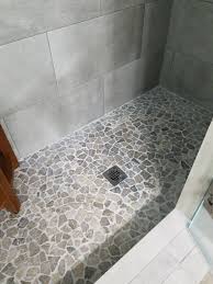 Serene And Airy Feeling Shower Remodel The Natural Flooring Is Stone Grey Mosaic Tile Https Pebble Tile Shower Floor Bathroom Shower Tile Shower Floor Tile