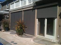 The shade sail, from shaded nation, covers a raised deck that can be used for dining or other activities. Exterior Sun Shades