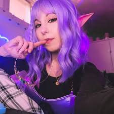 Prompt : Create a toy of the person in the photo, let it be an action  figure, next to the figure, there should be a work equipment like a  MacBook, iPhone, DSLR,