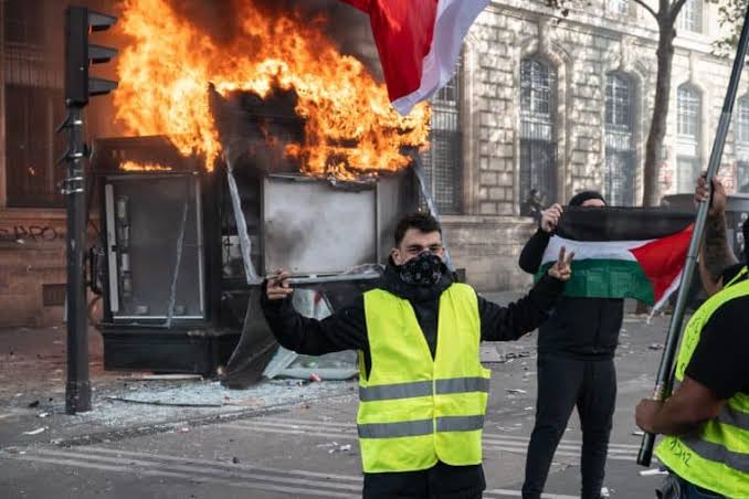 A street kiosk burns in central Paris as demonstrators take to the streets amid escalating nationwide anger over cost-of-living pressures and government policies., AI generated
