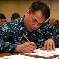U.S. Navy Petty Officer 1st Class Salisha Labonte, center, assists Afghan  National Police (ANP) Brigadier General Ahmad Rashad register senior ANP  members as they take a written exam.