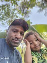 My home as a pikinini. Mu. Chimbu. My Dad Pastor Quast having a meeting  outside what would be our home. My view across coffee trees of Mu village.