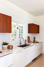 Upper cabinets don't come in one height or width, and they don't come in just one depth either. Bright Kitchen Features Wood Upper Cabinets And Modern White Lower Cabinets With A Built In Sink And Chrome Faucet Hgtv