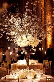 All White Flowers Branches And Hanging Candles Create A Stunning Winter Centerpiece Rustic Wedding Centerpieces Wedding Centerpieces Elegant Centerpieces