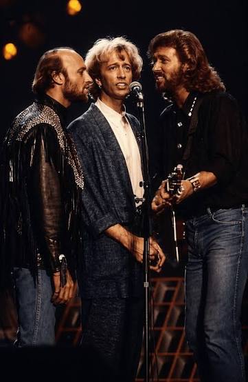 TWO SONS. ONE SONG. AND A LEGACY FINALLY GIVEN ROOM TO BREATHE. Adam Gibb and Robin John Gibb stood shoulder to shoulder—two sons carrying the weight of Bee Gees history—to record a