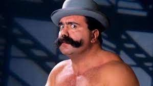 En çok 1991'de dünya güreş federasyonu (wwf) ile oynadığı ve 1920'lerden balıkçı yaka , melon şapka ve kral boy puro . Big Bully Busick Passes Away