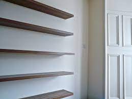 In the living room, leave plenty of space for furniture by displaying metal picture frames and marble sculptures on wall shelves. Walnut Floating Shelves Made To Measure For Alcoves And Walls