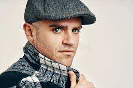 Trendy Man in Tweed Hat Over Soft White Background with Copy Space Stock  Photo