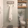 The pristine white tub, sink, and medicine cabinet really pop against the ridged ceiling, stone walls, and wood floors. 3