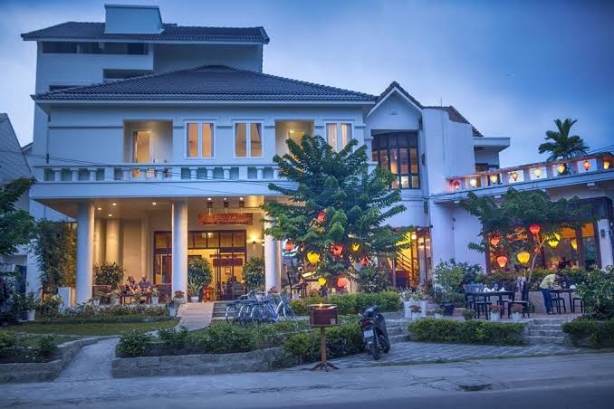 Phòng nghỉ tại Boutique Hoi An Resort mang phong cách thuộc địa hiện đại, có ban công riêng và không gian thoáng đãng hướng về phía biển.