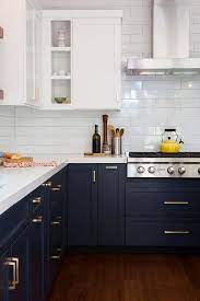 A new larger window floods the kitchen in natural light. White And Blue Kitchen Features White Upper Cabinets And Navy Blue Lower Cabinets Adorned With Ag Kitchen Design Kitchen Inspirations Kitchen Cabinets Makeover