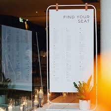 picture of a simple white metal stand with a seating chart