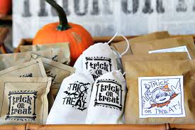 Next, punch two holes at the top of the ghost treat bags and thread ribbon through the holes of the bag and the ghost tag. Diy Halloween Trick Or Treat Bags A Free Printable