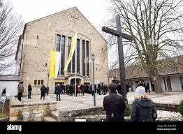 Wolfsburg, Germany. 24th Jan, 2023. Several people stand outside St.  Christopher's Church before the start of the public funeral service for  former VW Group CEO Carl Horst Hahn. Hahn was chairman of