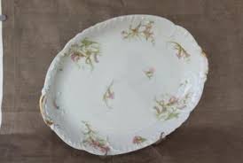 Orange roses and blue small flowers with silk ribbon in a floral arrangement. Antique And Vintage Platters