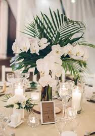 Palm Leaves And White Orchids Are A Classic And Chic Combo For Any Weddin Tropical Wedding Centerpieces Wedding Floral Centerpieces Flower Centerpieces Wedding