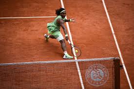 Serena williams reacts to winning a point at the net during her third round defeat of danielle collins at the french open.credit.pete kiehart for paris — serena williams's tennis dress was green and billowed in the breeze. R6nufril8d 4gm