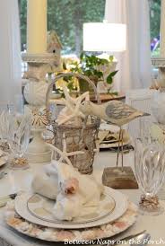 A beach wedding tablescape with a fabric runner and napkins, blue plates, candles and driftwood looks natural and beautiful. Beachy Tablescapes Between Naps On The Porch