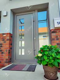 The use of modern, stylish colours will help freshen and revitalise the exterior. Entrance Door To Modern Grey House With Paving Footpath And Beautiful Potted Plants Bushes And Green Grass Stock Photo Picture And Royalty Free Image Image 149673843