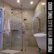 heavy glass enclosure with satin hardware pivot hinges and in glass towel hooks photo courtesy of art glass shower glass shower doors frameless shower doors