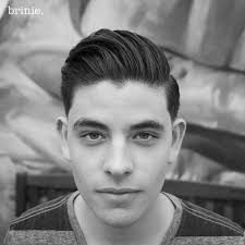 Young white guy with a pompadour hairstyle dressed in black shirt with a serious face isolated on white background. 30 Best Pompadour Hairstyles For Men 2020 Styles
