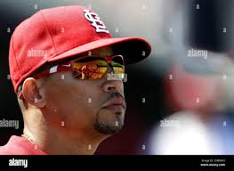 St. Louis Cardinals third base coach Jose Oquendo is reflected in the  sunglasses of shortstop Rafael Furcal as they talk in the dugout during the  second inning of an exhibition spring training