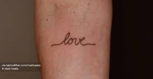 Love" lettering tattoo on the inner forearm.