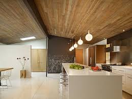 Warm Modern Kitchen White Quartz Countertops With A Waterfall Edge Love The Wood Ceiling Mid Century Modern Kitchen Modern Remodel Mid Century Modern House