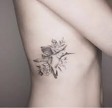 Bird Tattoo On Ribs Done In Black And Grey This Tattoo Is Small And Shows A Bird Amid Some Leaves Fl Bird Tattoos For Women Hummingbird Tattoo Meaning Hummingbird Flower Tattoos