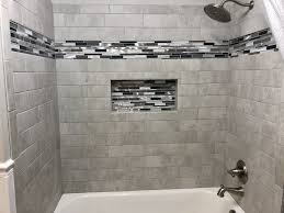 Wood strips in painted flat white make up the wall in the background. Bathroom Remodel Bathrooms Remodel Shower Tile Designs Shower Tile