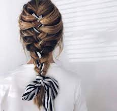 Woman With Long Bronde Hair Styled Into A French Braid Updo With A Scarf Weaved Through It Wearing Wh Braids For Long Hair Hair Scarf Styles Thick Hair Styles