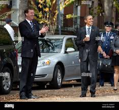 President Barack Obama jokes with reporters during a walk with White House  Travel Director Marvin Nicholson (left) back to the White House following a  luncheon at The Metropolitan Club with former senators