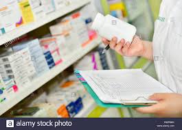 Pharmacist Holding Medicine Bottle And Prescription Chart