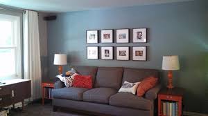 When we see blue, we're transported. Gray Living Room Blue Wall Gray Sofa Orange Accent Tables Picture Wall Living Room Orange Blue Walls Living Room Living Room Decor Gray