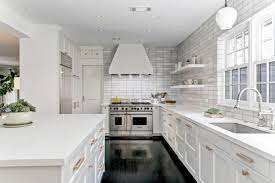 Gold and white pulls on glossy green cabinets in a transitional kitchen boasting updated stainless steel appliances, wood floors and gold. Modern White Kitchen With Stainless Steel Appliances And Gold Hardware Hgtv