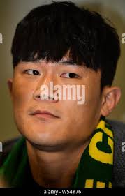 South Korean football player Kim Young-gwon, right, of China's Guangzhou  Evergrande Taobao FC heads the ball against a player of South Korea's Jeju  Un Stock Photo