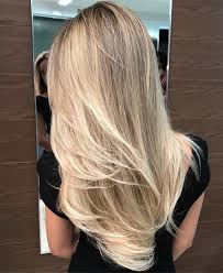 Very shiny blonde hair settling on a sweater tied around the waist. 50 New Long Hairstyles With Layers For 2020 Hair Adviser